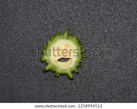 Slices of Momordica charantia Fruit with black background. It also known as many names Balsam-pear Bitter melon,apple,squash. Commonly known as Bitter Gourd.