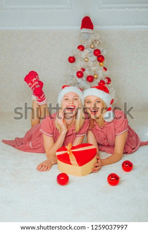 Christmas Best friends girl. White christmas tree red balls. Joyful friends celebrate christmas at home