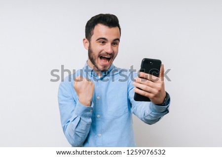 Happy young man is winner in online lottery Royalty-Free Stock Photo #1259076532