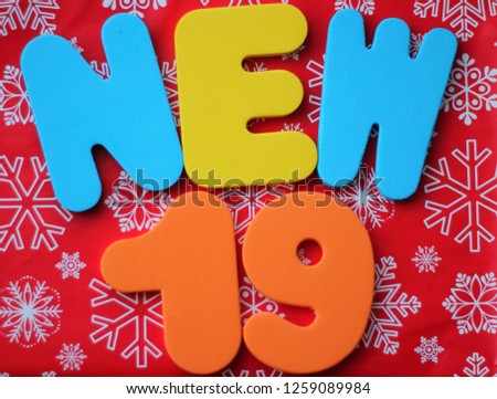 words New Year, 2019, from plastic bright color letters, against the background of Santa's cap, Christmas mood