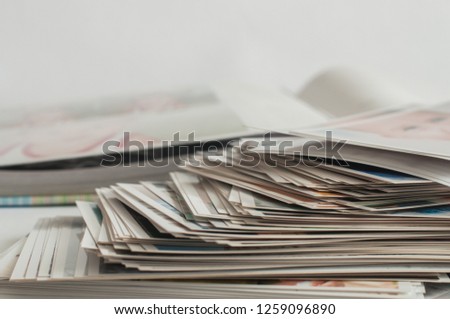 Photo album and pile of printed photographs on a white background.