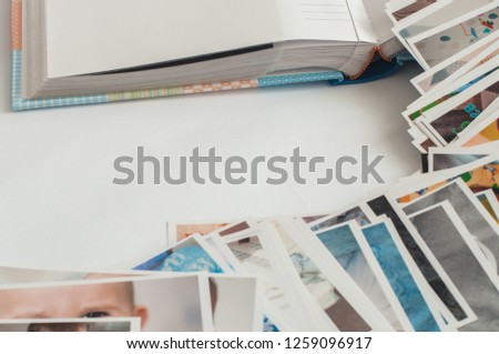 Pile of printed photographs in disorder and photo album. White background in the center.
