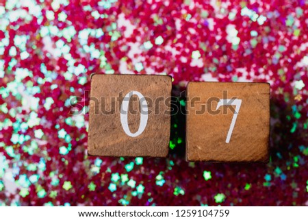 Christmas background. Winter background. Advent calendar. Countdown to Christmas. Wooden numbers. Shiny background. Pink stars. Multicolored confetti.