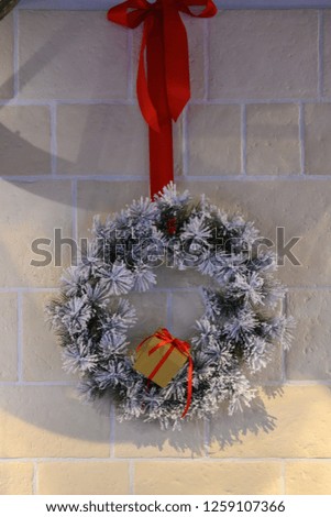 Christmas wreath with red ribbon in front of a beautiful wall