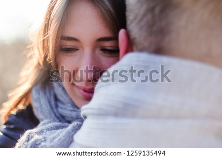 holidays, winter, christmas, hot drinks and people concept - happy couple in warm clothes hugging near the tree branches with snow