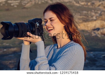 happy woman with a camera on the nature in the mountains, travel                           