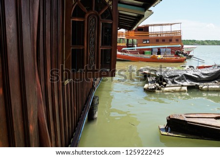 The small fishing village with beautiful wood houses and boats in Phang Nga Province of Thailand. Brown And Green Background.