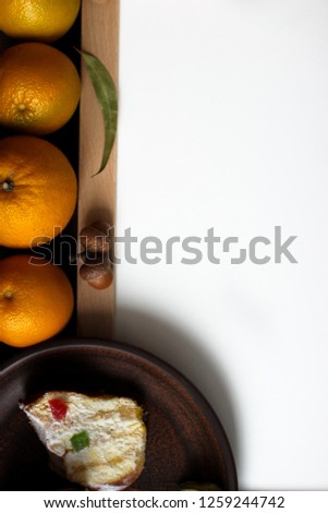 Top view of Christmas decor with copy space area. Christmas objects: dried sliced orange, cinnamon, pine cone, fir branch, cup coffee, cheesecake, walnut, golden Christmas bells