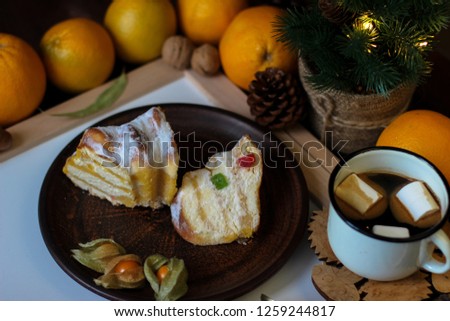 View of Christmas decor. Christmas objects: dried sliced orange, cinnamon, pine cone, fir branch, cup coffee, cheesecake, walnut, golden Christmas bells.