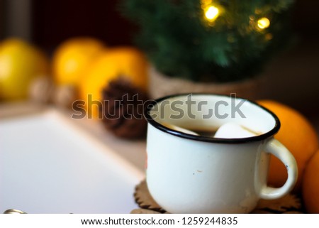 Top view of Christmas decor with copy space area. Christmas objects: dried sliced orange, mandarines, cinnamon, pine cone, fir branch, cup coffee, cheesecake, walnut, golden Christmas bells