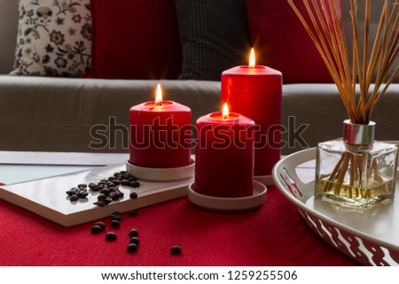 Christmas or new year decoration with red candle and coffee . Living room interior and holiday home decor concept.