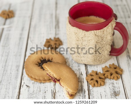 Winter morning, cups of coffee with knitted cup holders, gingerbread and vanilla cookies on a white wooden background.Cozy winter breakfast.Ideal for winter couple in love. Copy space, selective focus