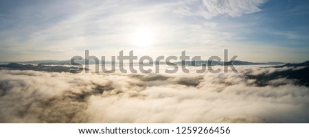 Panorama image Drone shot of Beautiful scenery sunlight in the morning sunrise above flowing fog waves on mountain tropical rainforest in phang nga thailand.