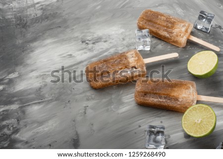 ice cream flavored soda on a stick. Bright color, summer mood. Eskimo with lime and apple, refreshing and with ice on a dark background. Flat-lay