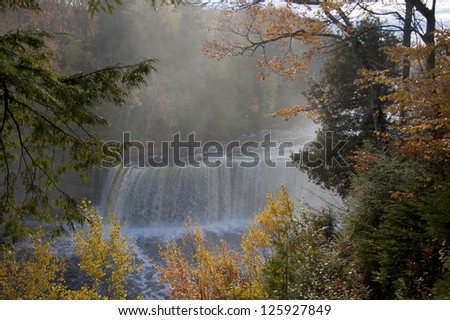 Waterfall in Autumn forest framed by fall foliage
