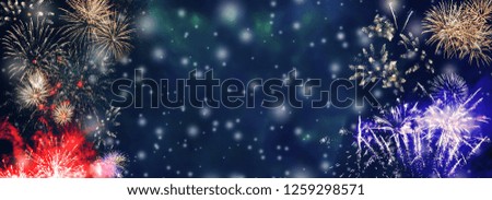 Colorful fireworks background with falling snow at night and with free space for text