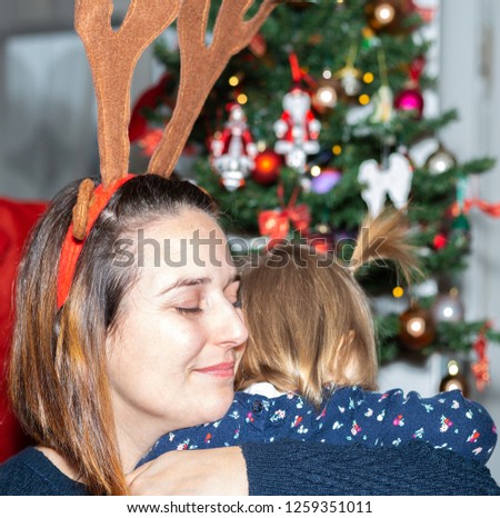 Beautiful 14 monts old baby girl and her mother on holiday time with christmas and new year decoration
