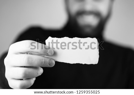 a small white piece of paper in his hand man