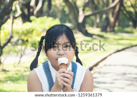 The girl is happy to eat ice cream in the garden.