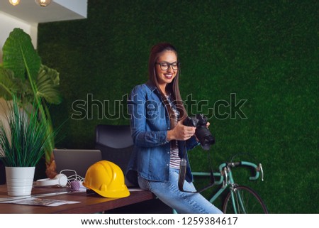 Female construction engineer looking a photos from construction site.