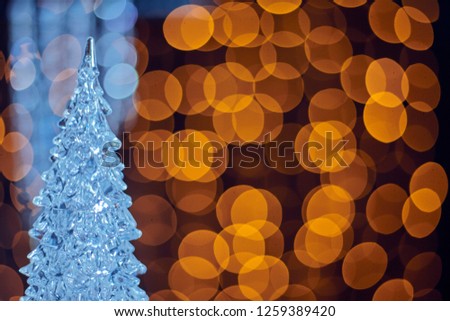 Blurred bokeh golden background with ice Christmas tree. Glittering decorations for the New Year and Christmas