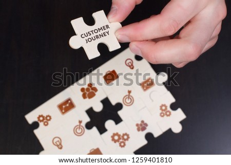 The concept of business, technology, the Internet and the network. A young businessman collects a puzzle with the proper inscription: Customer journey