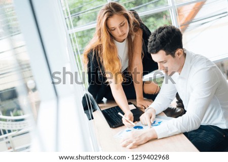 Businessman happy about his job with boss discussing while commenting a financial report document at meeting.