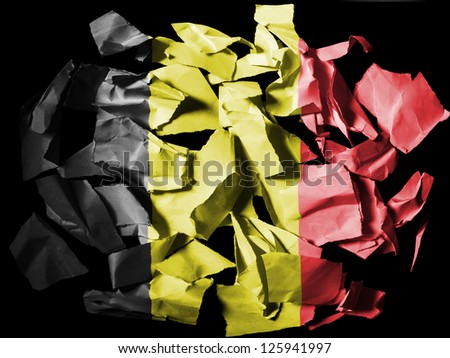 Belgium. Belgian flag painted on pieces of torn paper on black background