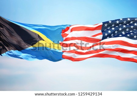 Flags of the USA and the Bahamas against the background of the blue sky