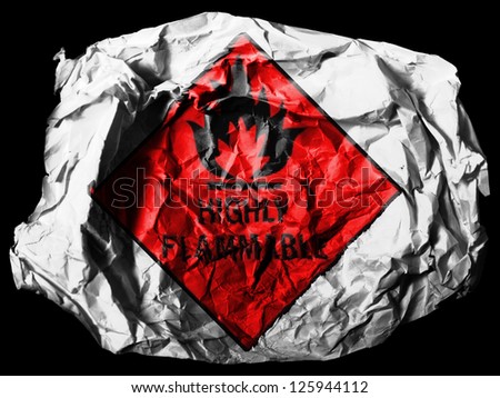 Highly flammable sign drawn on  painted on crumpled paper on black background
