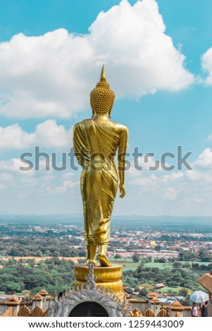 Golden Buddha standing on a mountain Wat Phra That Khao Noi duri