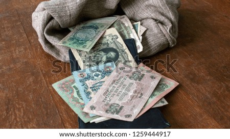 Old Russian paper money of the early 20th century on the background of a bag and an old wooden table.