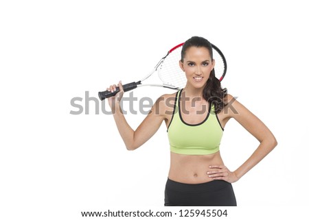 A happy woman holding a tennis racket. Photographed in studio.