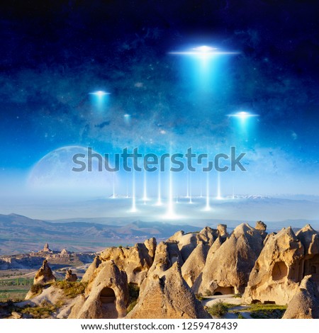 Amazing fantastic background - extraterrestrial aliens spaceship fly above surreal terrain, full moon rises above the horizon. Elements of this image furnished by NASA