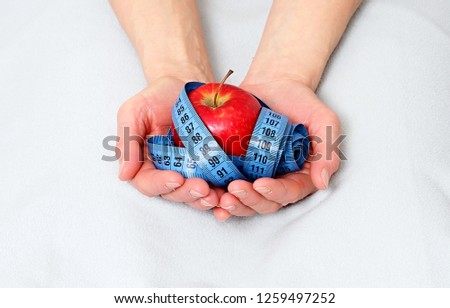 apple with tape measure representing dieting slimming and weight loss stock photo