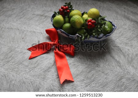 lots of lime in bowl with red ribbon
