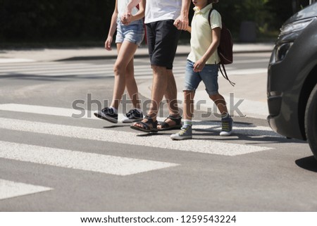 Children crossing the street with their father Royalty-Free Stock Photo #1259543224