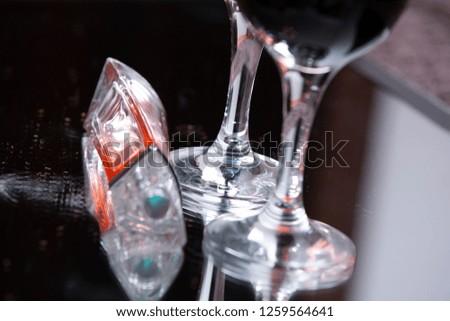 two glasses with red wine and perfume