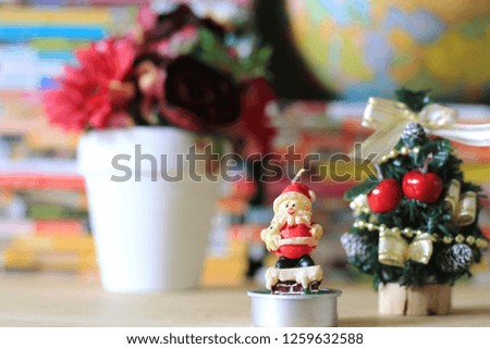 Little Santa's Candle on the table a small Christmas tree is the background selective focus and shallow depth of field