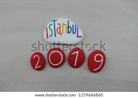 Istanbul 2019, logo type with a stones art composition over white sand