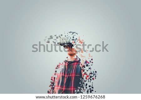 Asian man in tartan shirt wearing glasses of glasses of virtual reality dissolving into pixels on gray background Future technology Concept