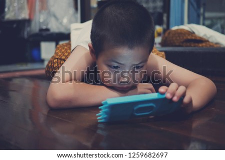 asian chinese boy playing smartphone on bed, watching smartphone, child use mobile, addicted game and cartoon, boy play phone
