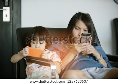  chinese child playing smartphone with mother, play phone, watching cartoon, family
