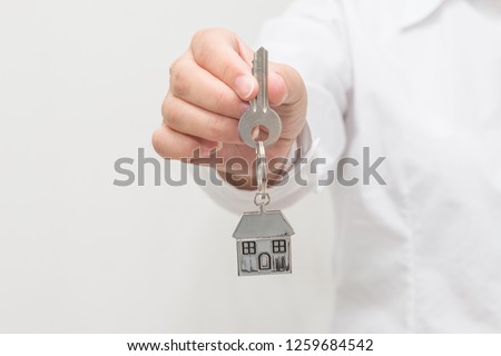 Woman hand holding house model and key