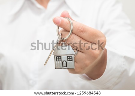 Woman hand holding house model and key