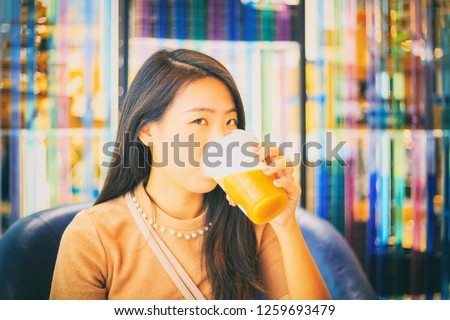 Vintage Photography style of pretty Asian woman drinking creamy tea in the coffee shop, indoor portrait, selected focus.