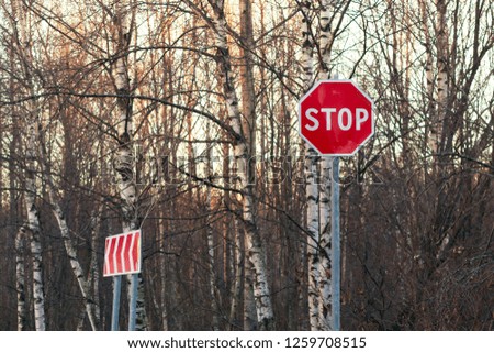 Stop sign and detour on the side of an asphalt road