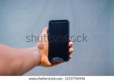 Hand holding a black phone