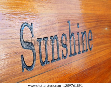 The varnished wood engraved with the word Sunshine