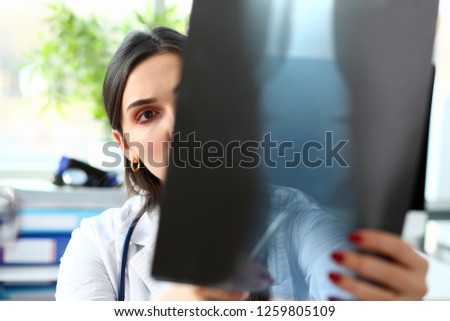 Female beautiful doctor hold in arm and look at xray photography discussing it with woman patient portrait. Bone disease exam medic assistance cancer test healthy lifestyle hospital practice concept